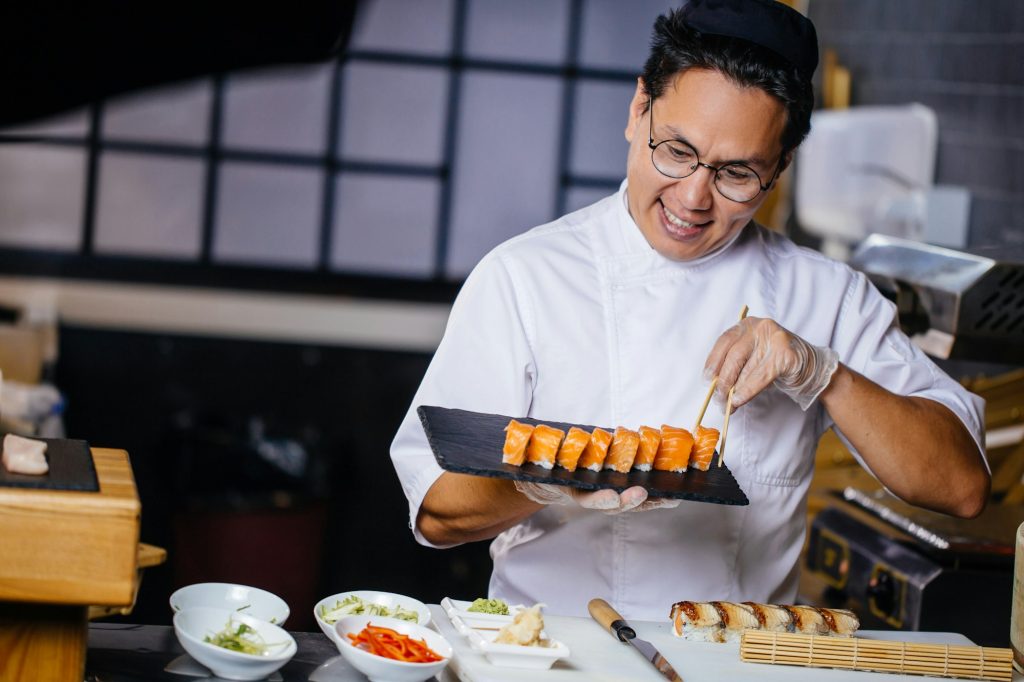 handsome chef in Japanese restaurant with sushi plate